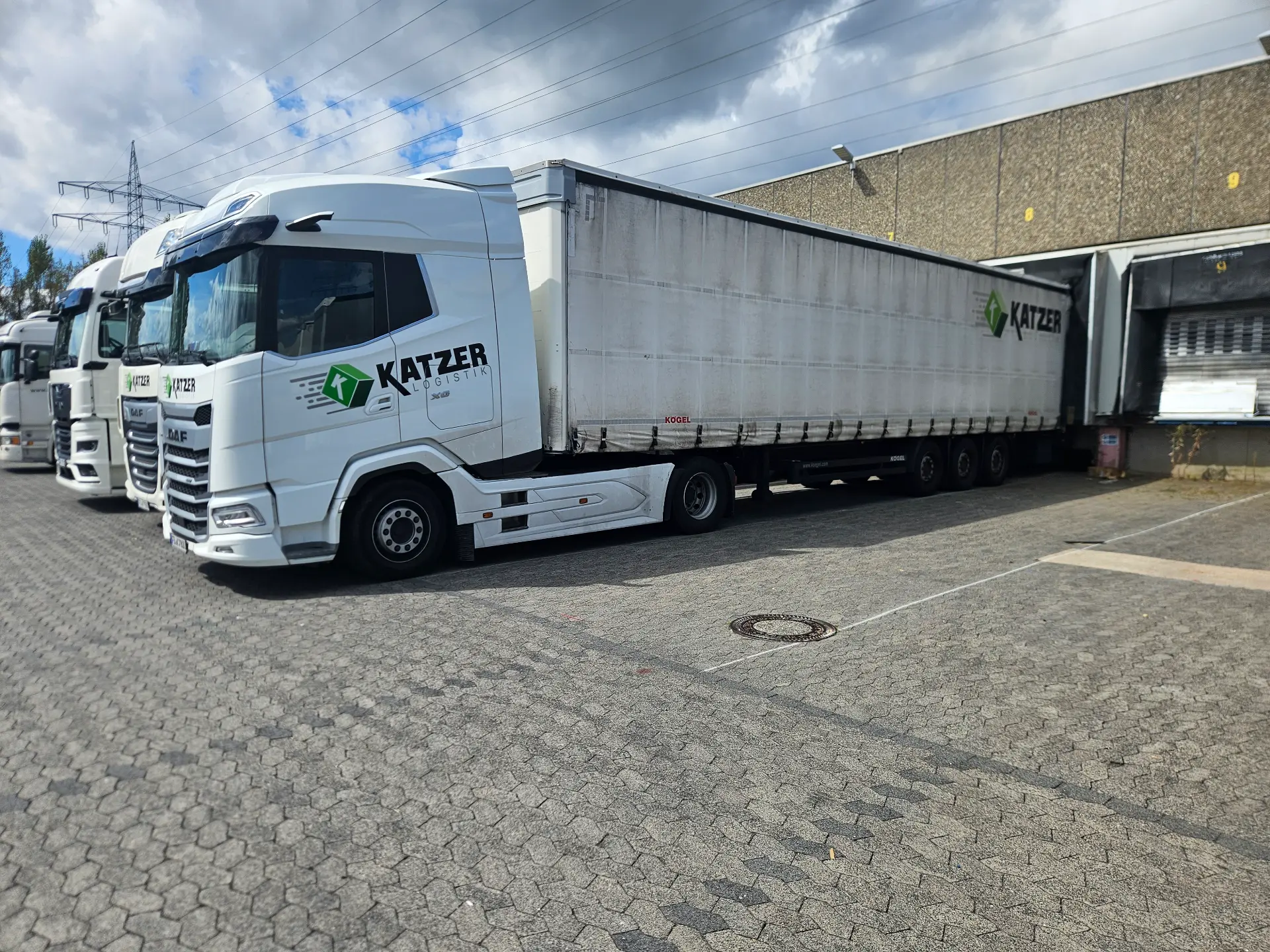 Fuhrpark der Katzer Logistik mit DAF-Zugmaschinen und Kögel-Auflieger an der Rampe